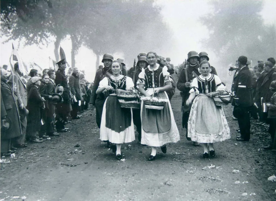 Images worthy of a painting were repeated in every village during the Hungarian entry into southern Slovakia (Upper Hungary). The hardworking inhabitants of Hungarian villages, dressed in festive attire, awaited the arrival of Hungarian troops, whom they greeted with decorated gates, flags, and flowers. Many of the soldiers would remember this moment their entire lives.
